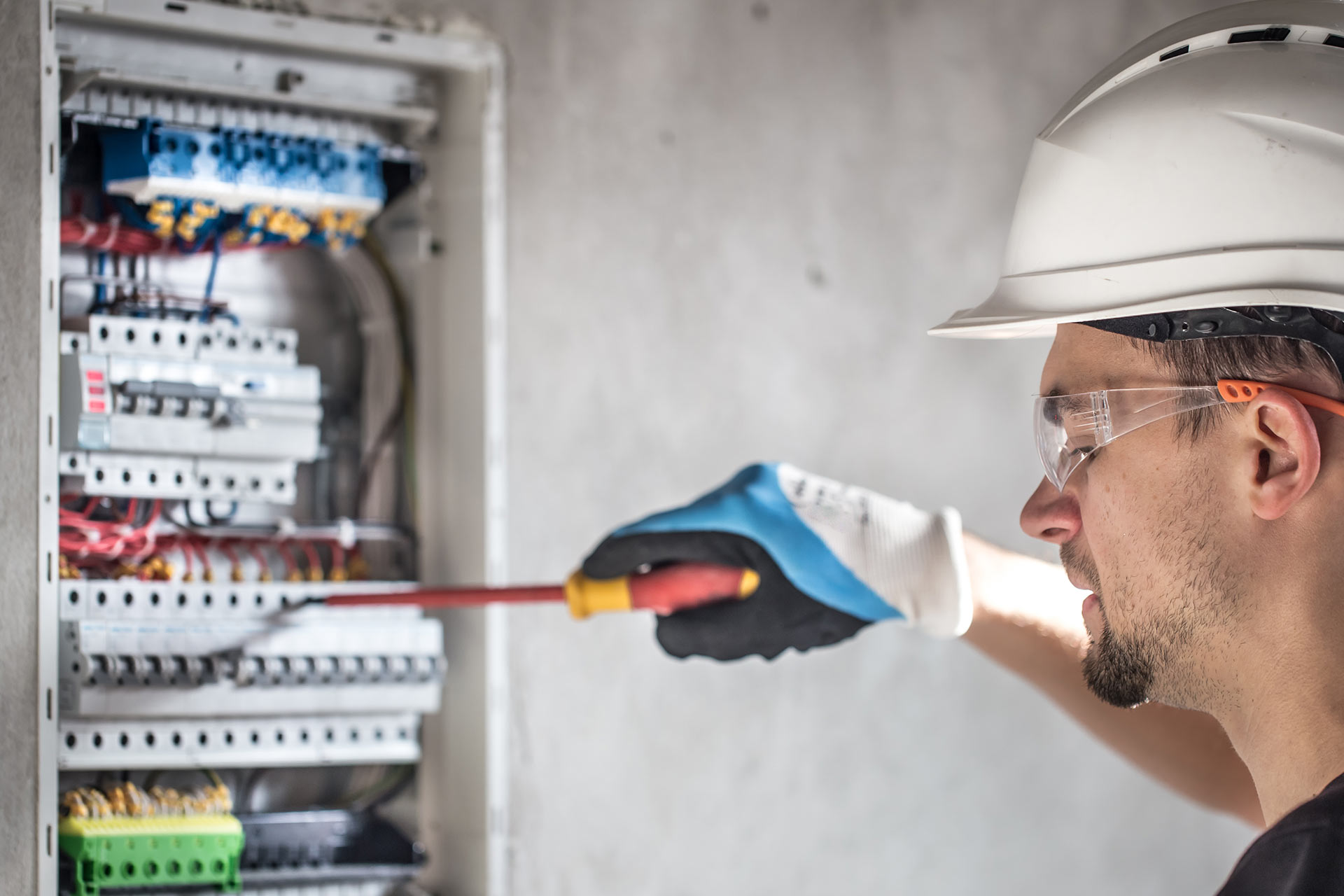 Male electrical technician working on a switchbox.