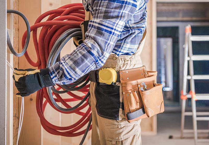 Electrician installing electrical cables and wiring in an apartment.